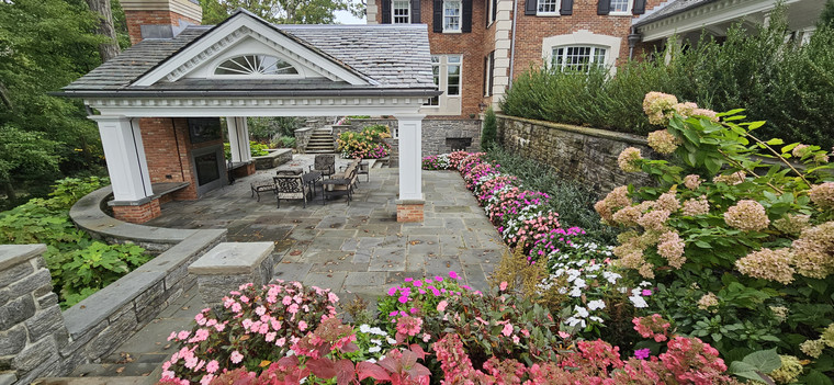 Garden pavilion surrounded by flowering borders and stone terraces
