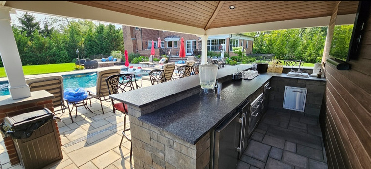 Outdoor kitchen pavilion overlooking a pool terrace