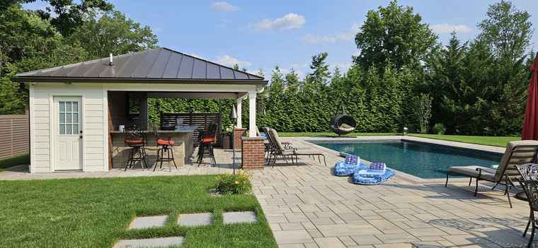Modern pool with paver deck, cabana bar, and pergola seating