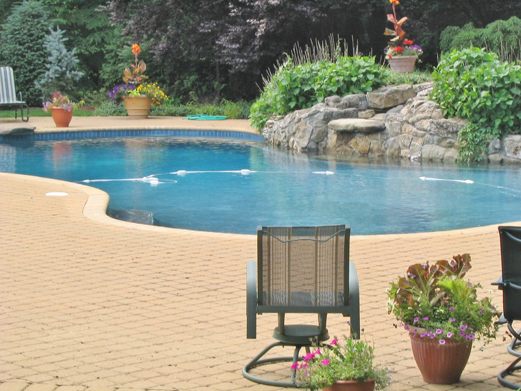 Freeform pool with natural rock waterfall and lush poolside plantings