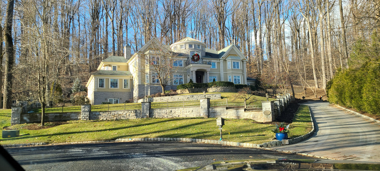 Tiered stone front-yard walls supporting an estate landscape